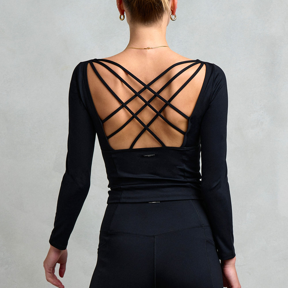 Back detailing of Stretch Studio London's Kensington Square Neck Cross Back Top, featuring long sleeves and a strappy cross back. 